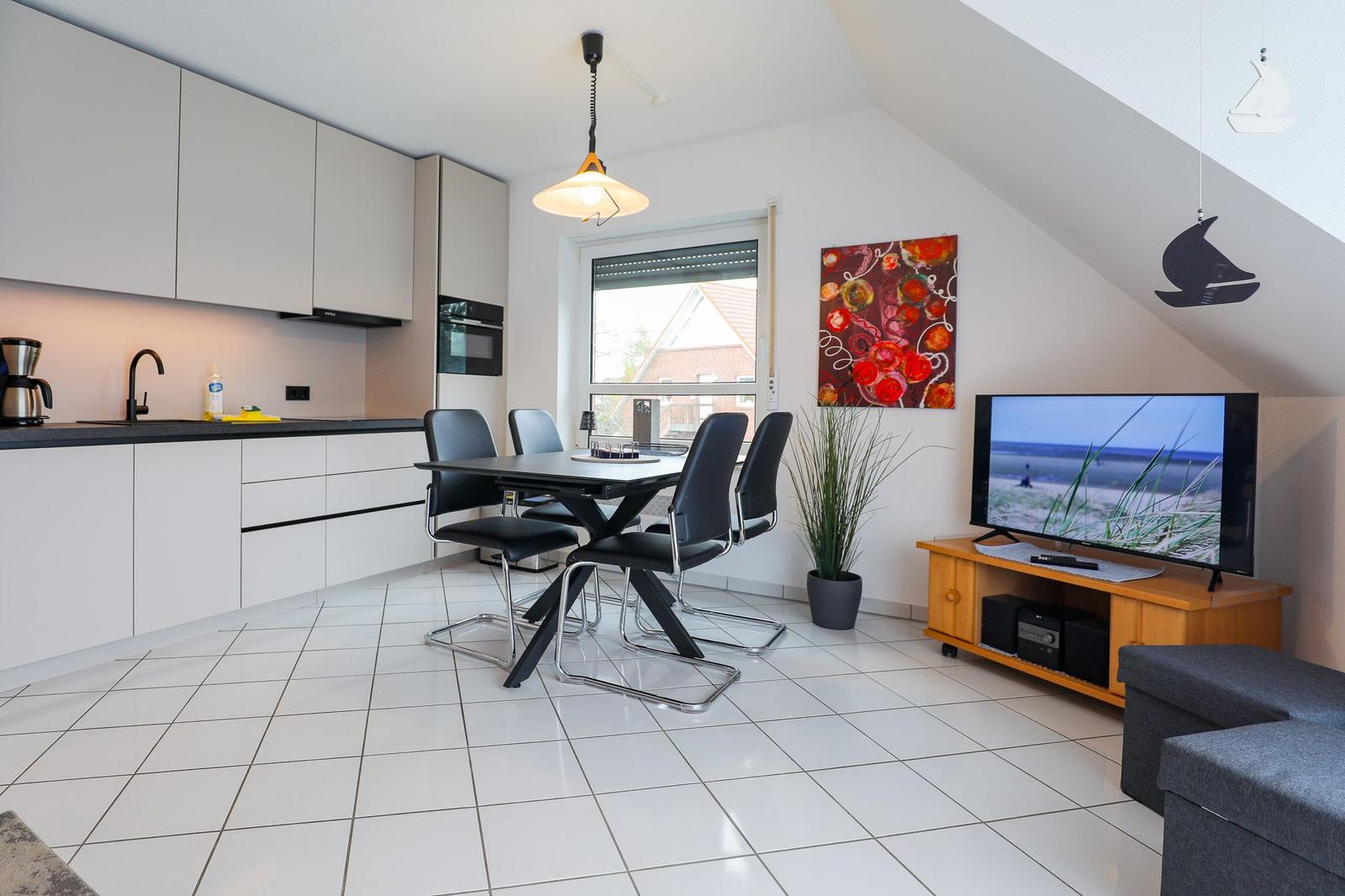 Küche mit Esstisch, Fernseher und Wandbild in Dachwohnung