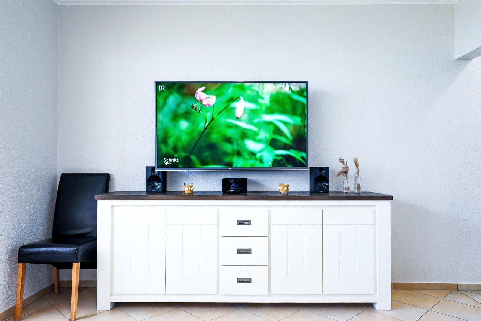 TV auf weißen Schrank mit Lautsprechern und Dekoration