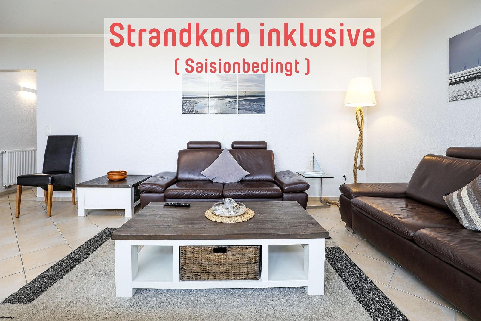 Wohnzimmer mit braunen Ledersofas, Holztisch und Strandkorb inklusive.