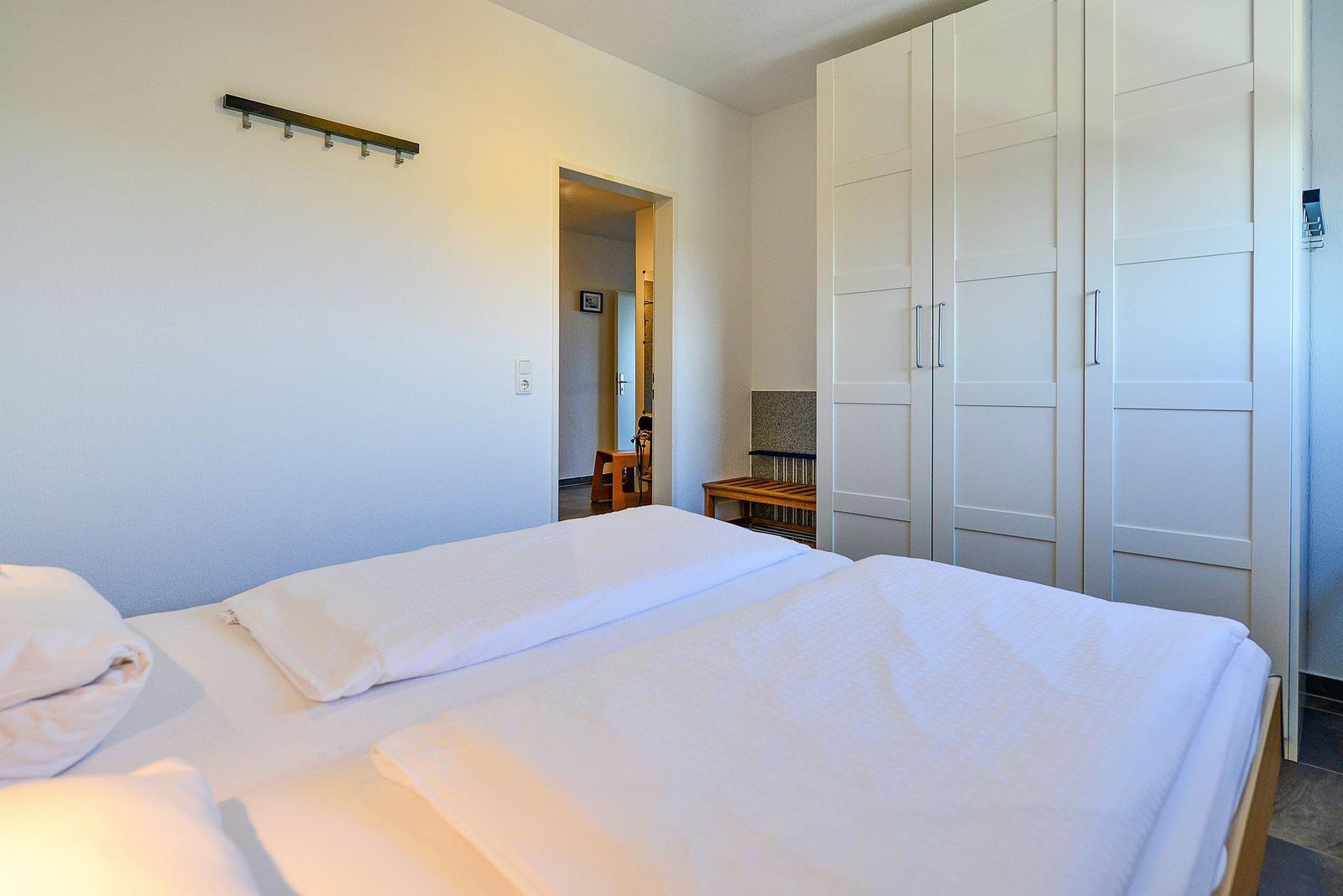 Ein Schlafzimmer mit einem Bett, einem Kleiderschrank und einem Durchgang.
