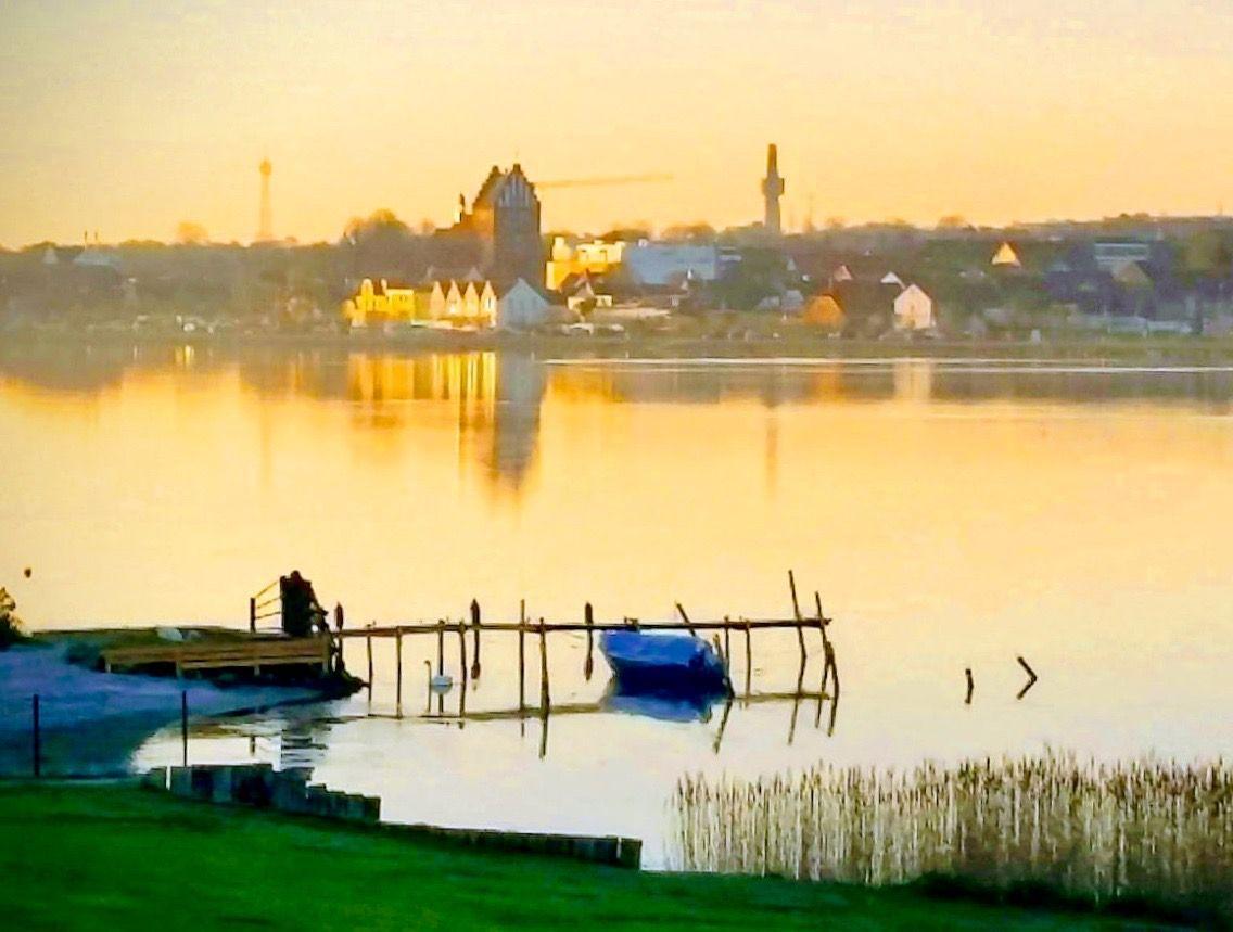 Hafen mit Boot und Blick auf Stadt bei Sonnenuntergang