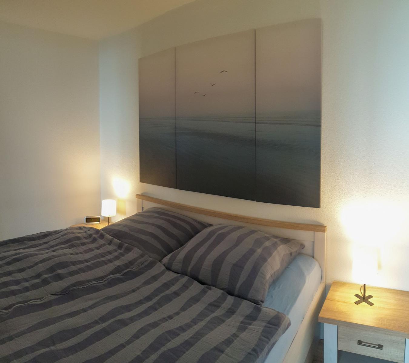 Bedroom with bed, nightstands, and wall art