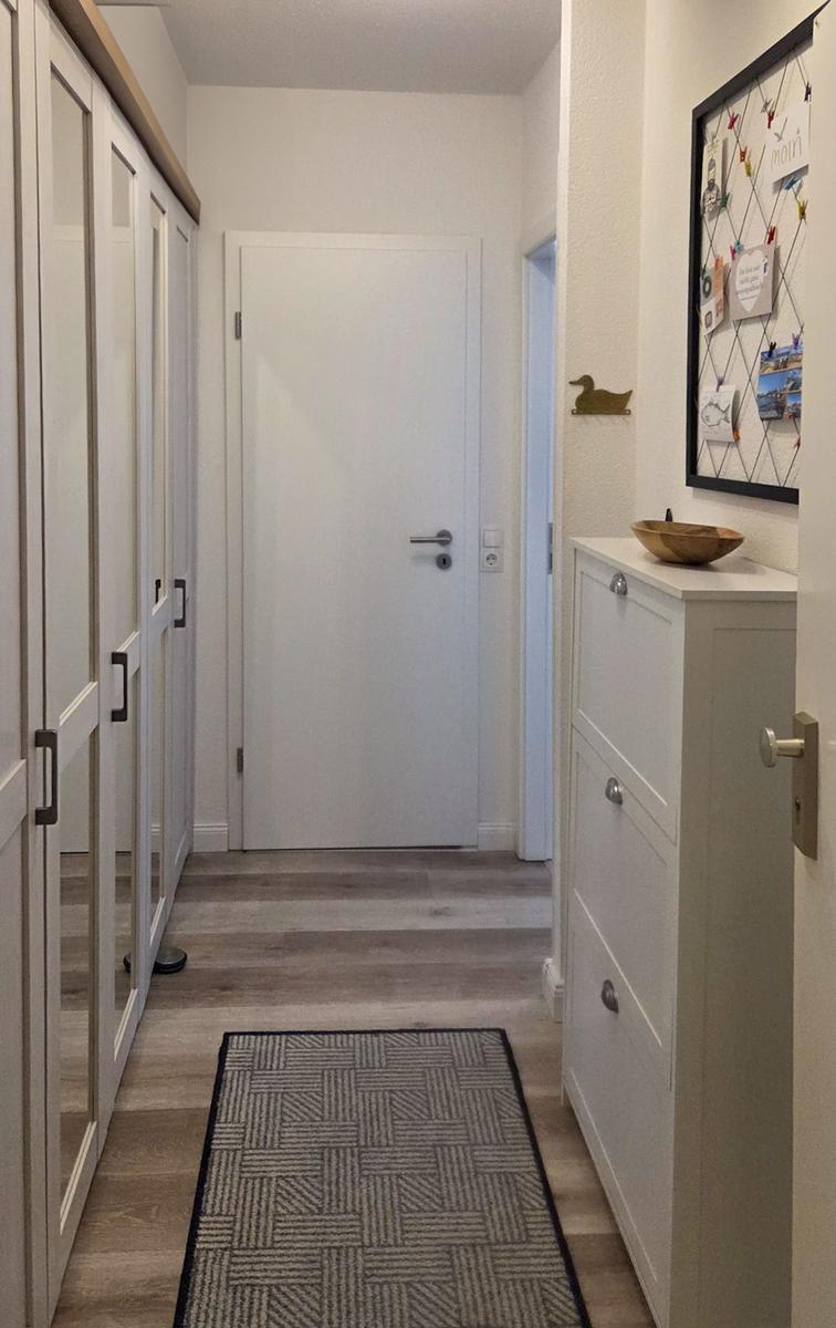Hallway with wardrobe, drawer, and rug