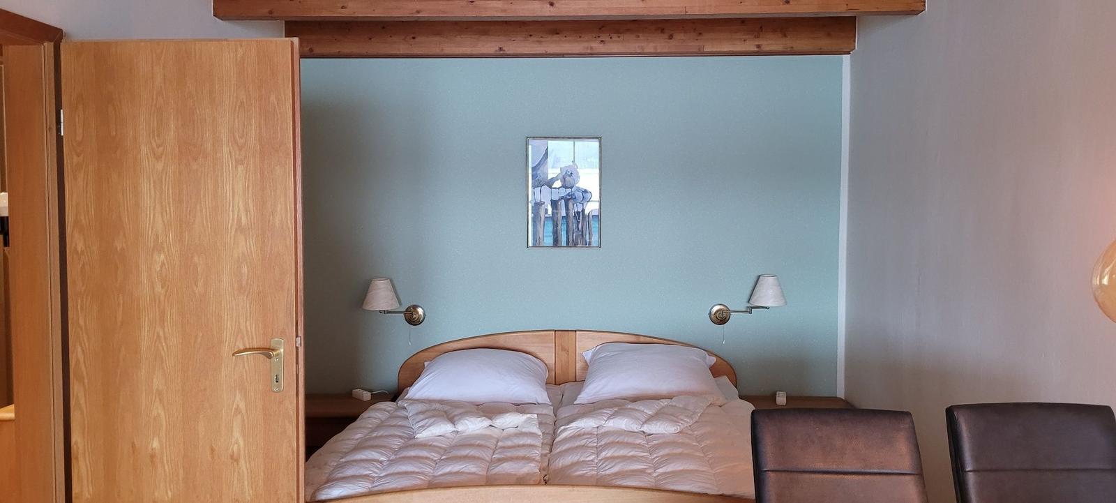 Ein Schlafzimmer mit einem Bett, zwei Nachttischen und einer Tür.