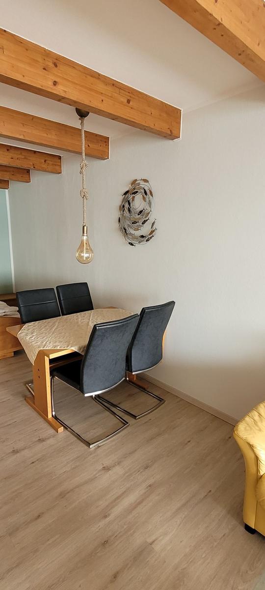 Essbereich mit Tisch, Stühlen und Holzbalken an der Decke.