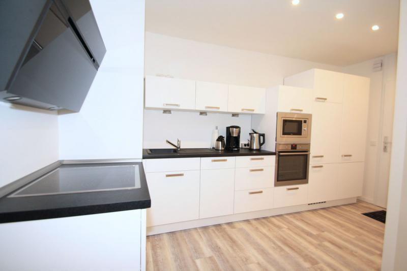 Modern kitchen with white cabinets, black countertop, and built-in oven.