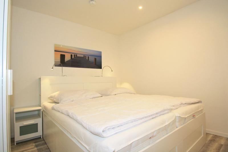 Bedroom with double bed, nightstand, and wall picture.