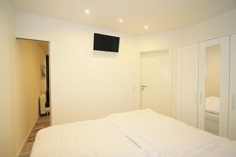 Bedroom with bed, wardrobe, and wall-mounted TV