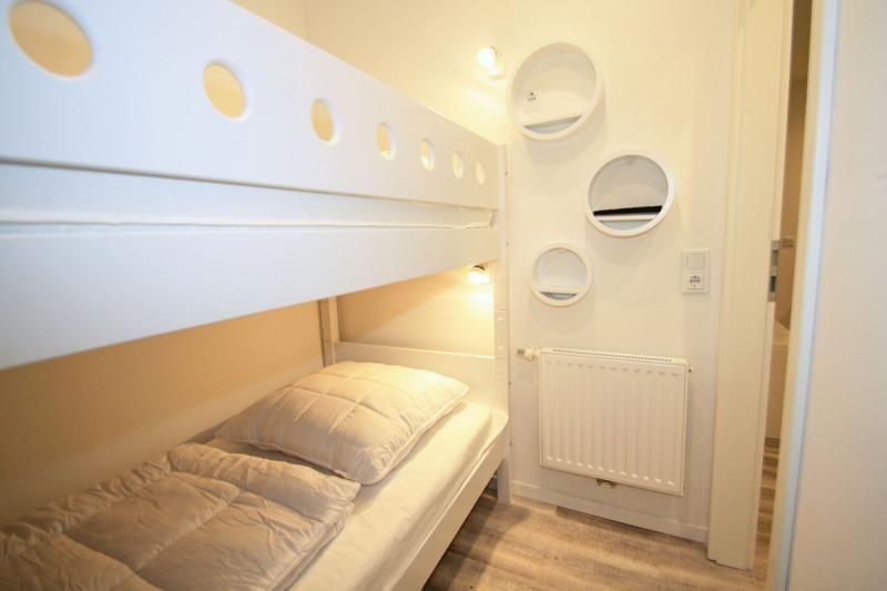 Room with bunk bed and round wall holders.