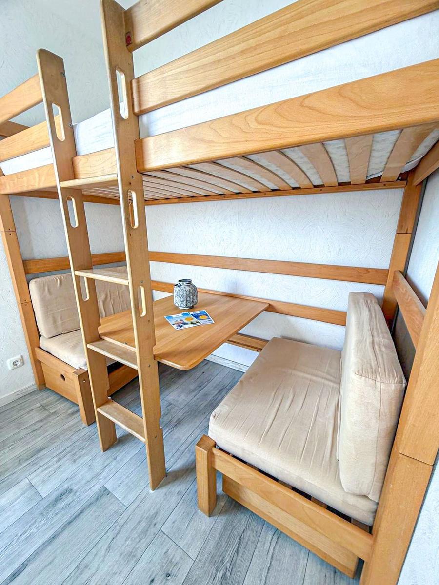 Etagenbett mit integriertem Schreibtisch und Sitzgelegenheiten aus Holz.