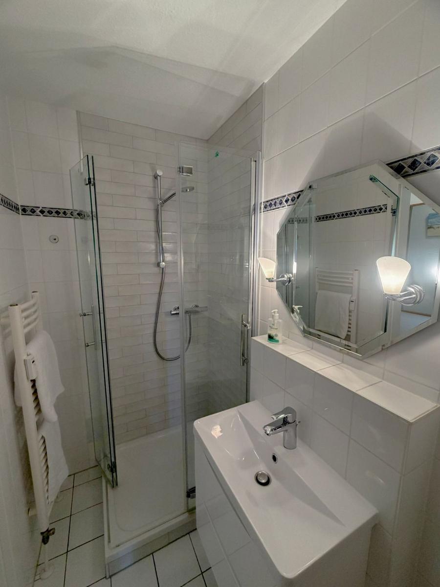 Bathroom with shower, sink, and mirror.