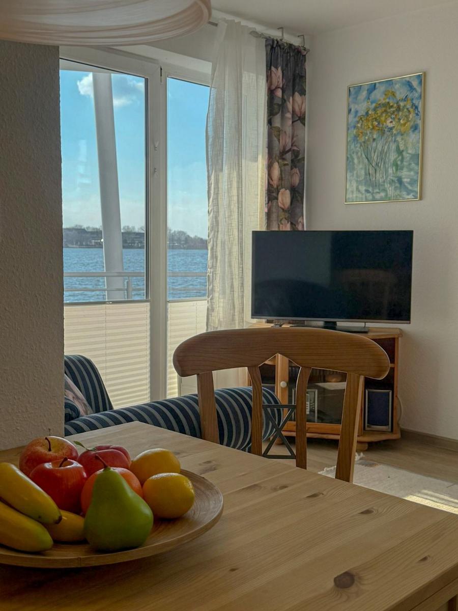 Dining room with water view, TV, and fruit bowl on table