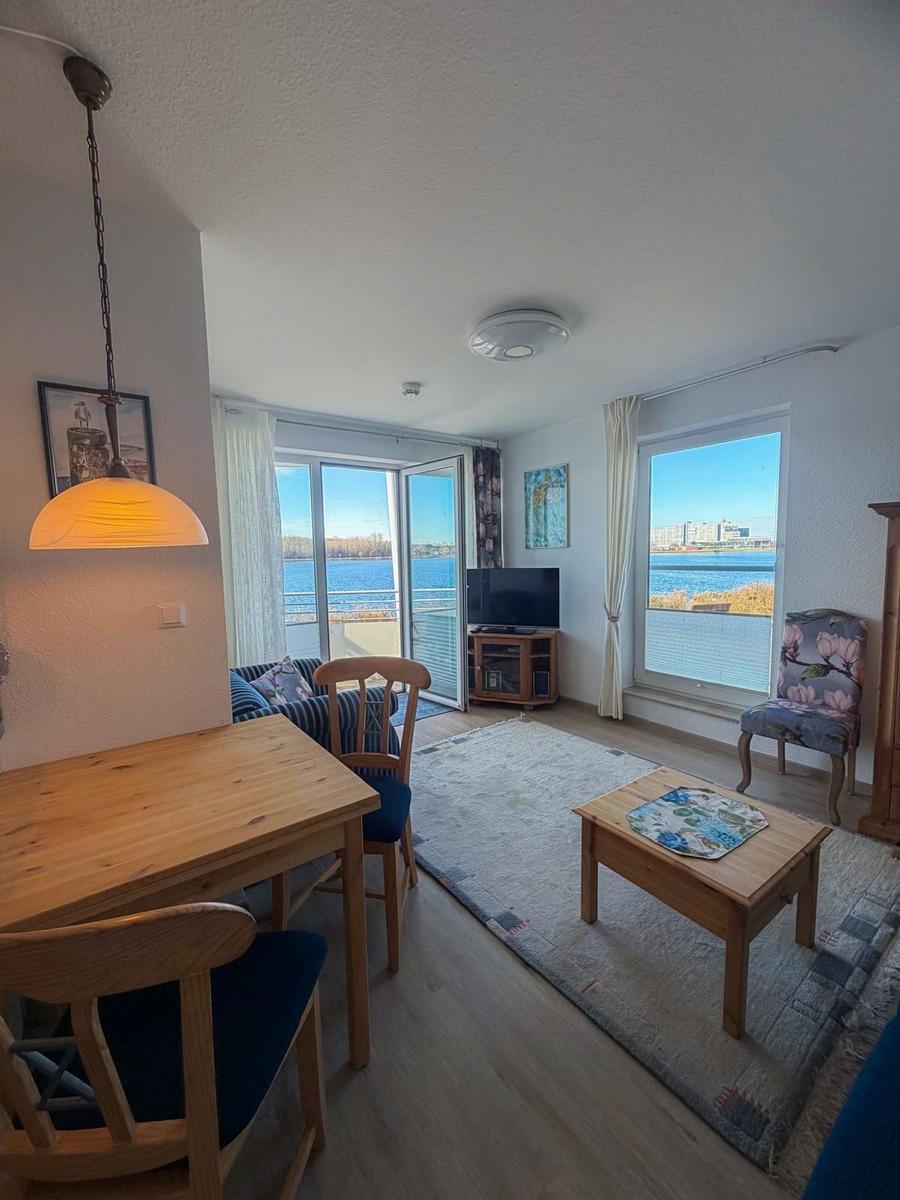 Living area with dining space, TV, and water view.
