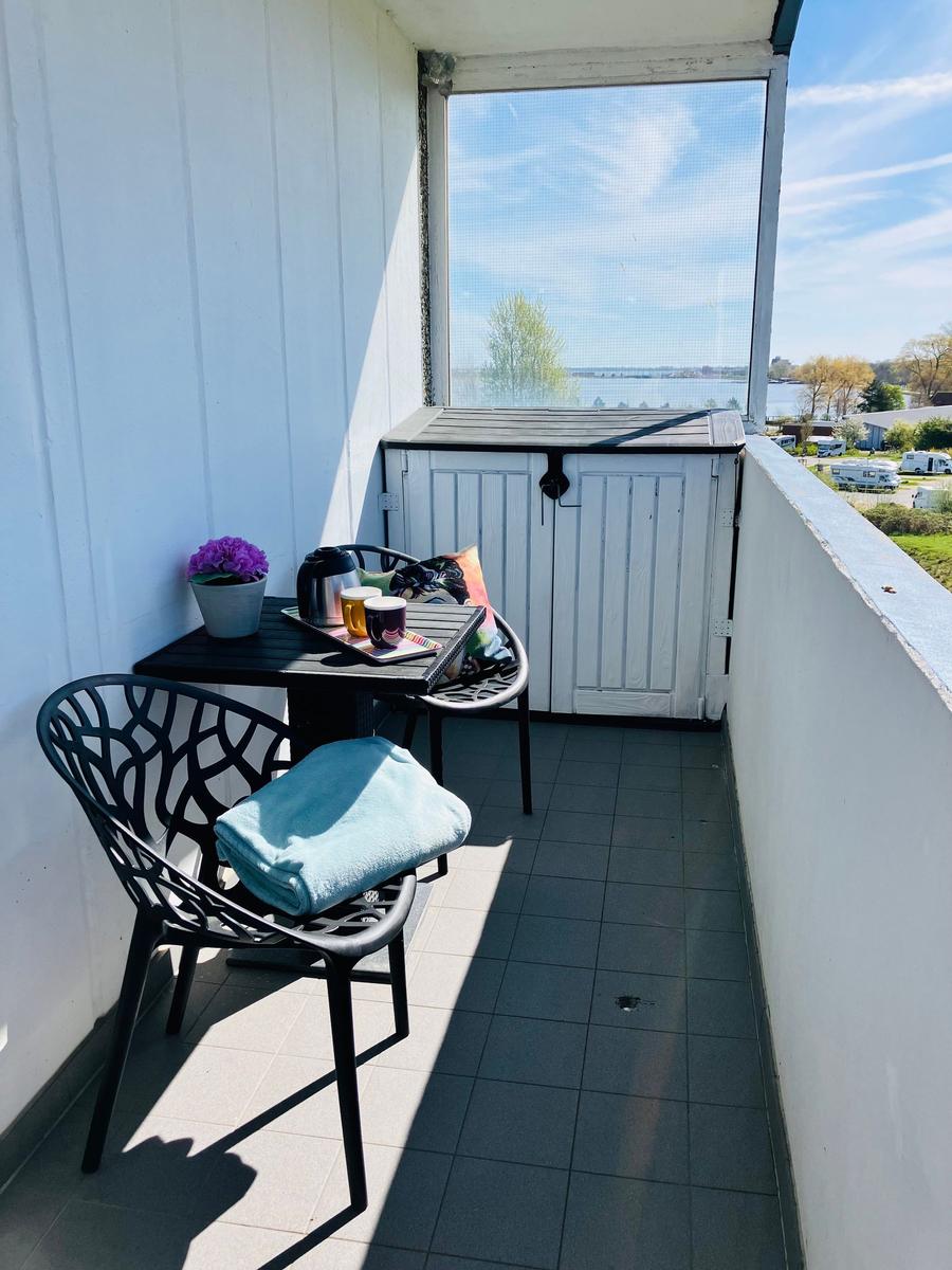 Terrasse mit Tisch, zwei Stühlen und Blick auf Wasser