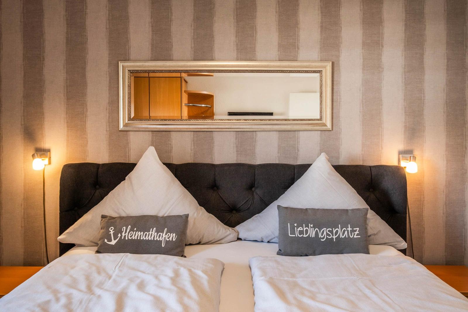 Double bed with pillows and mirror on the wall