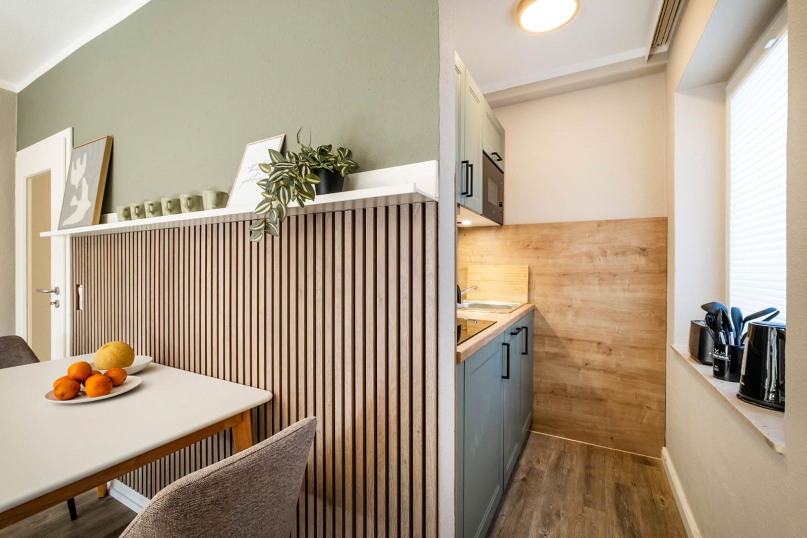 Küche mit Holzwand und Essbereich mit Tisch und Stühlen