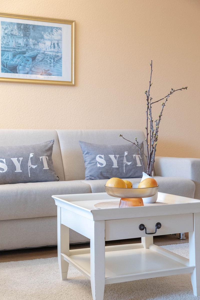Ein Wohnzimmer mit Sofa, Kaffeetisch und Wandbild.
