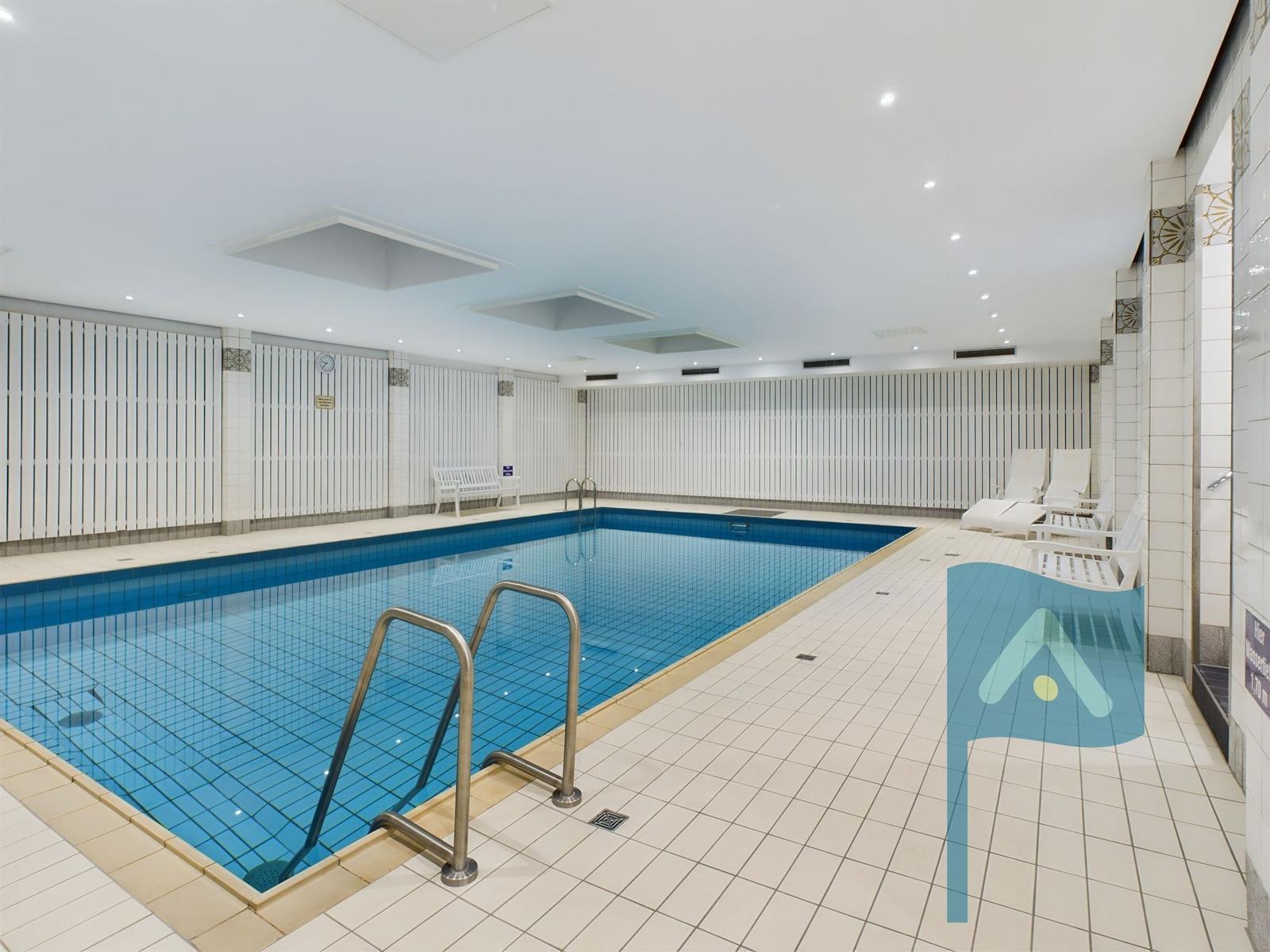 Innenpool mit Liegen und metallenen Stufen