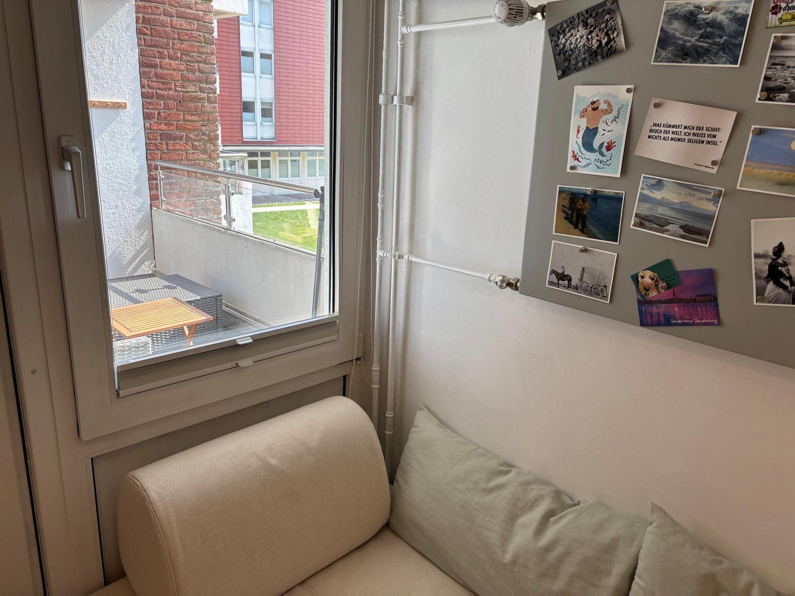 Sitzgelegenheit mit Blick auf Balkon und Wand mit Fotos