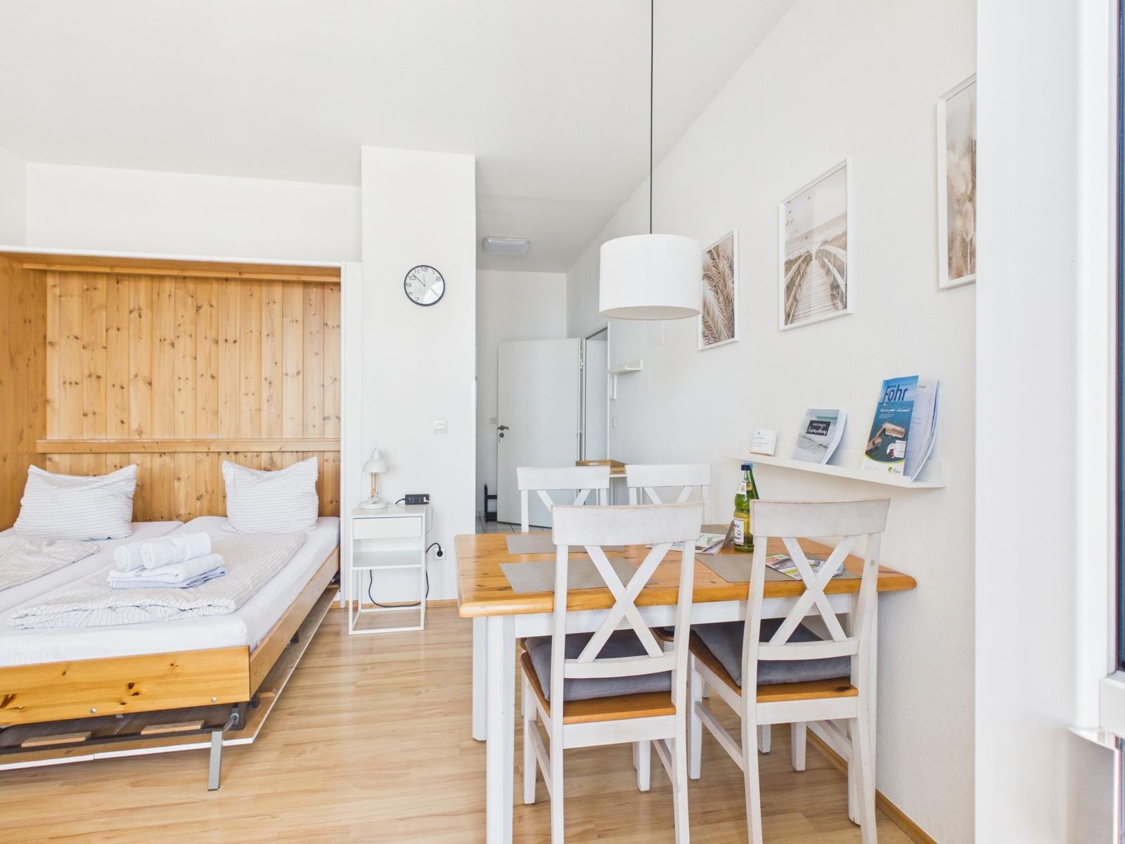 Bedroom with bed and dining area with table and chairs.