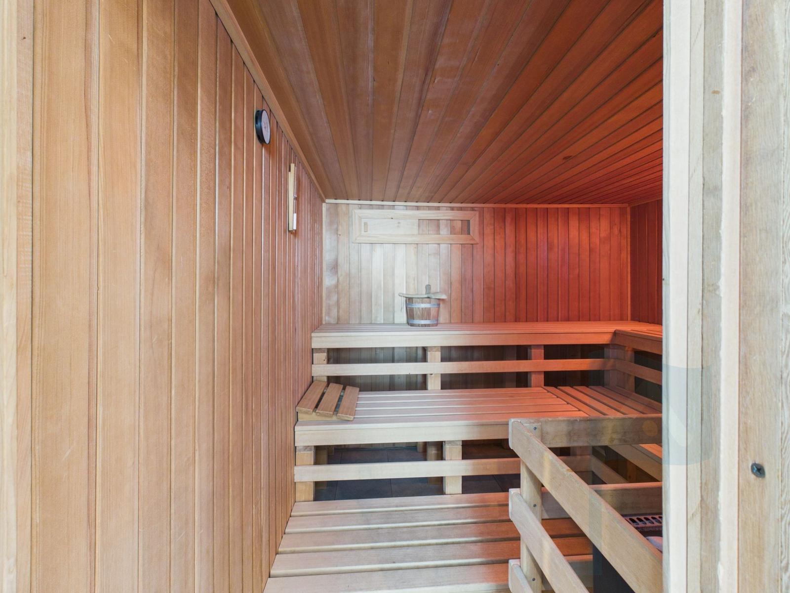 Wooden sauna with benches and bucket