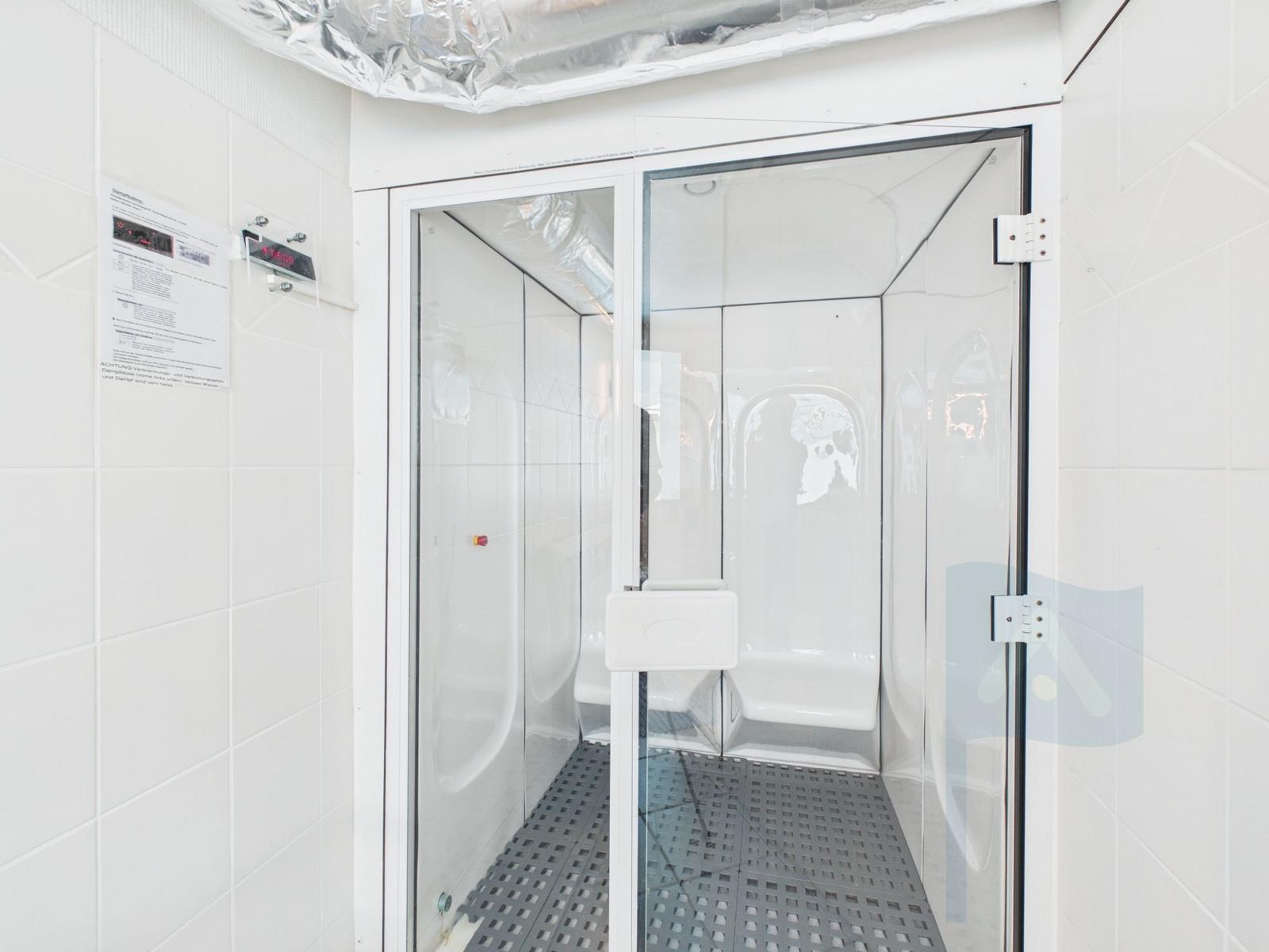 Steam room with glass door and control panel on the wall