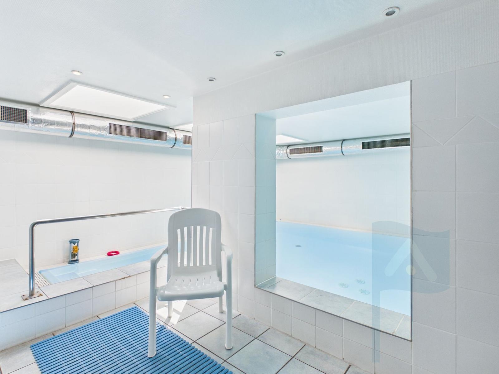 Indoor pool with seating area and shower