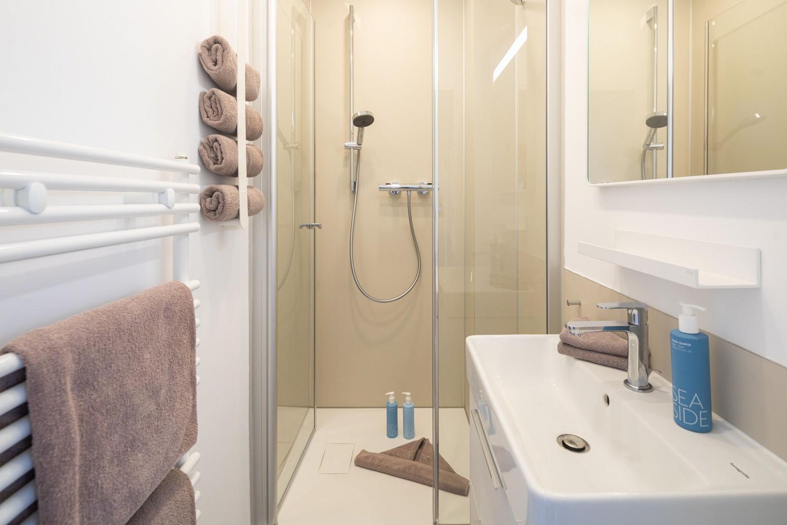 Bad mit Dusche, Waschbecken und Handtüchern
