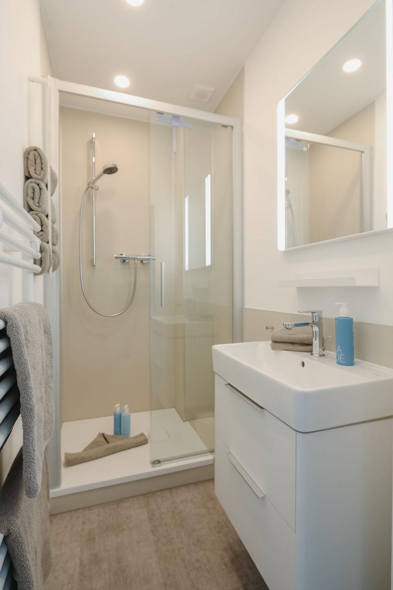 Bathroom with shower, sink, and mirror. Towels and soap are available.