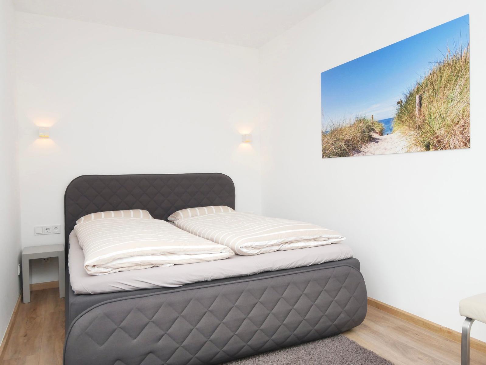 Schlafzimmer mit Doppelbett, Wandbild und Nachttisch