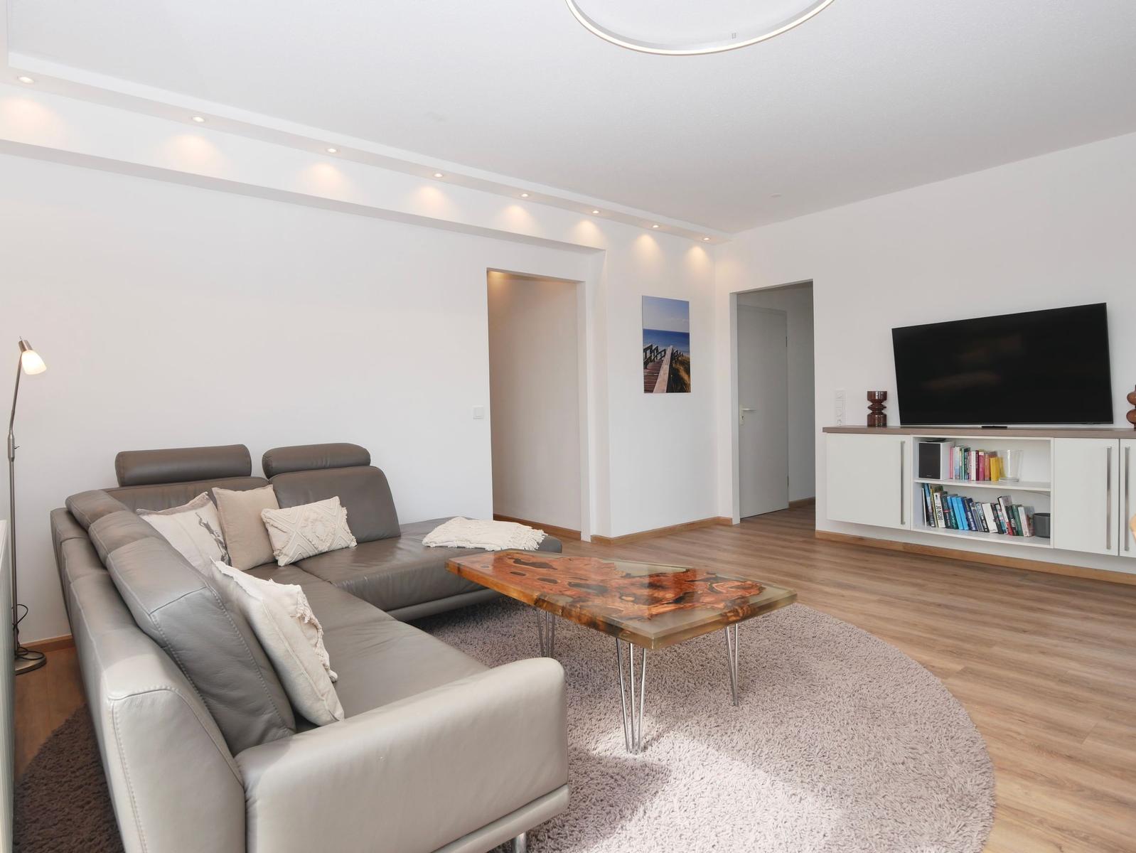 Wohnzimmer mit Sofa, Couchtisch und Fernseher