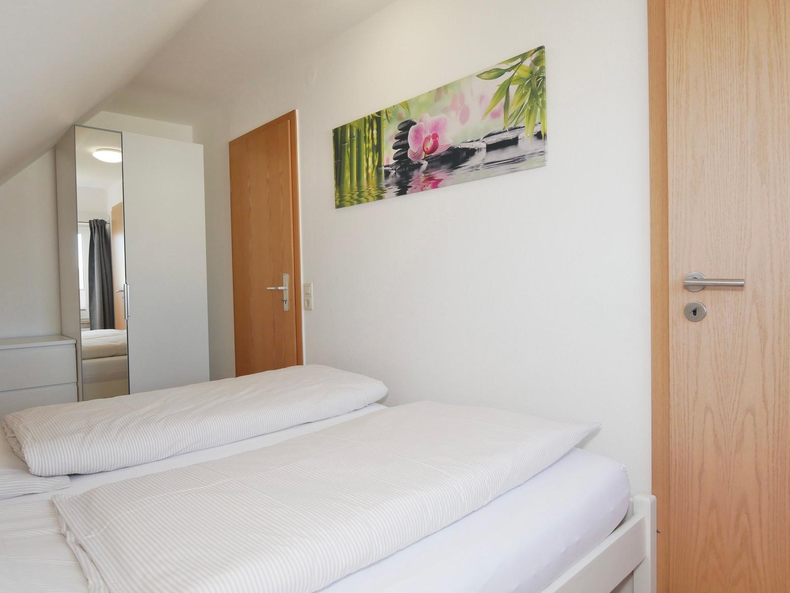 Schlafzimmer mit Bett, Wandbild und Tür