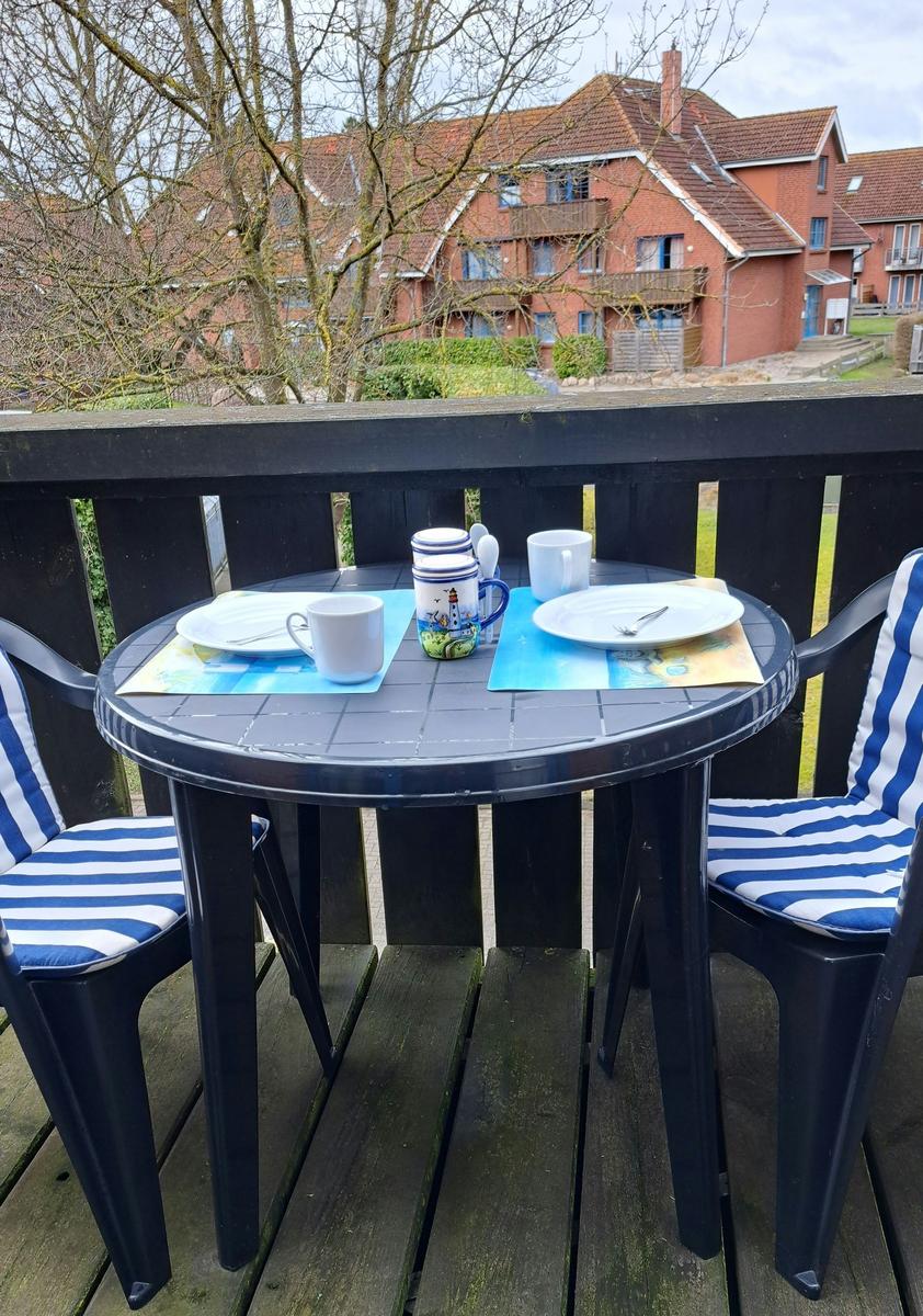 Terrasse mit Tisch und zwei Stühlen, Blick auf Wohnhäuser