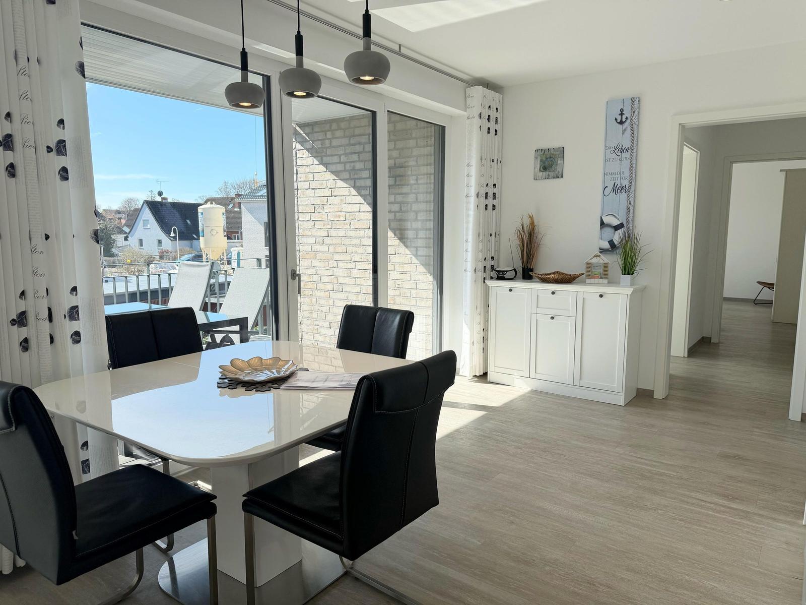 Esszimmer mit Tisch, Stühlen und Blick auf Balkon