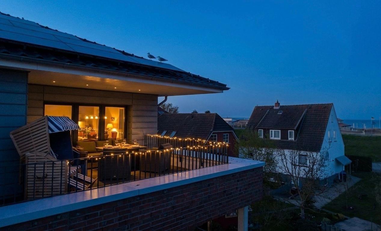 Terrasse mit Beleuchtung, Blick auf Wohnhaus und Strand