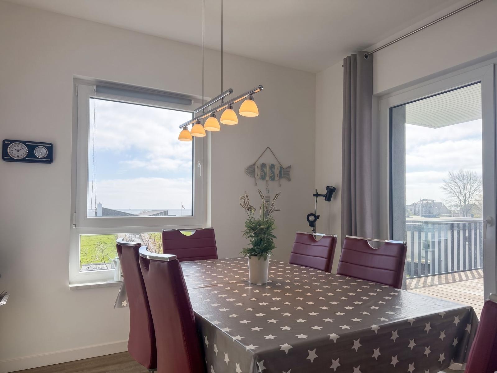 Esszimmer mit Tisch, Stühlen und Blick auf Balkon und See