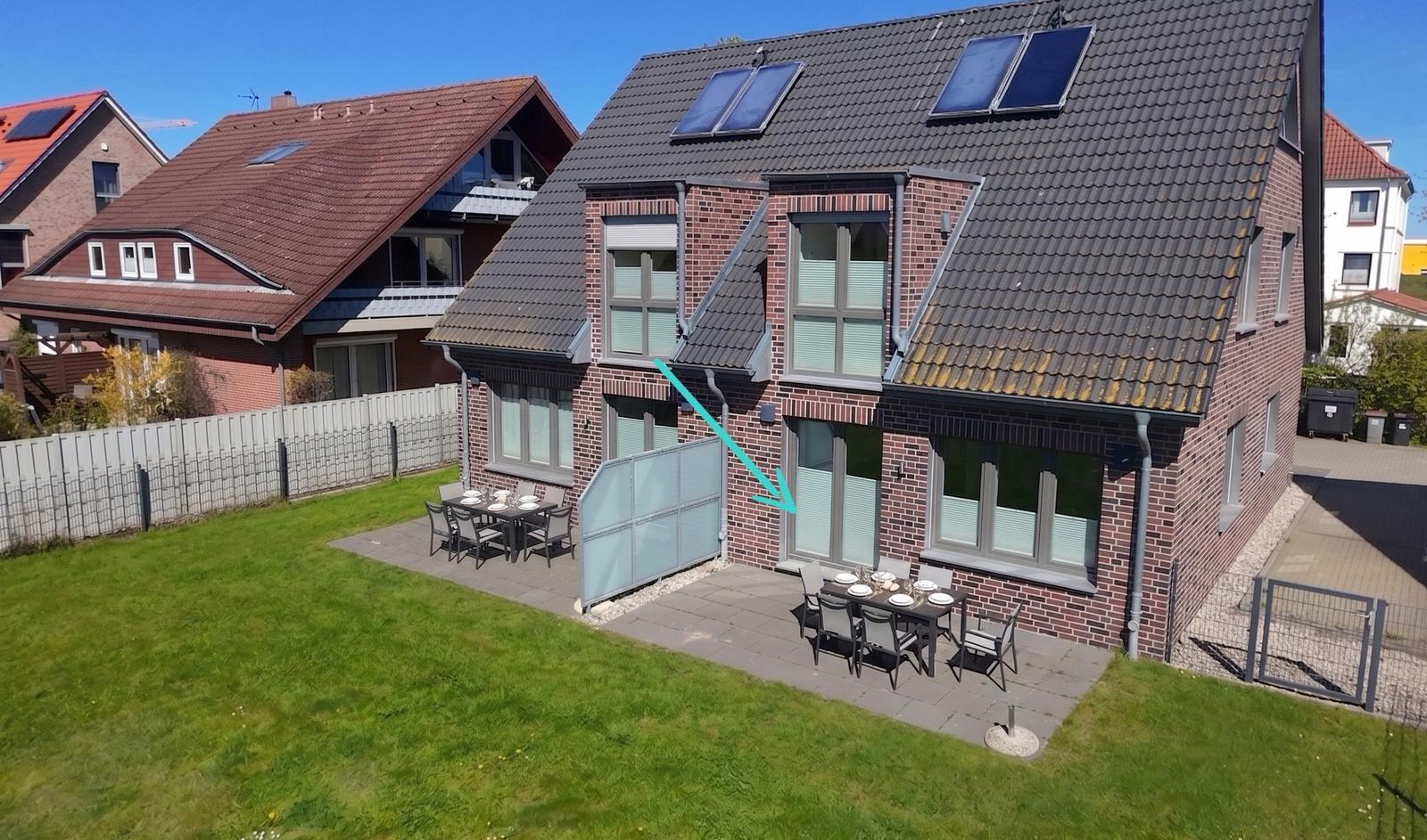 Haus mit Garten, Terrasse und Sonnenkollektoren auf dem Dach.