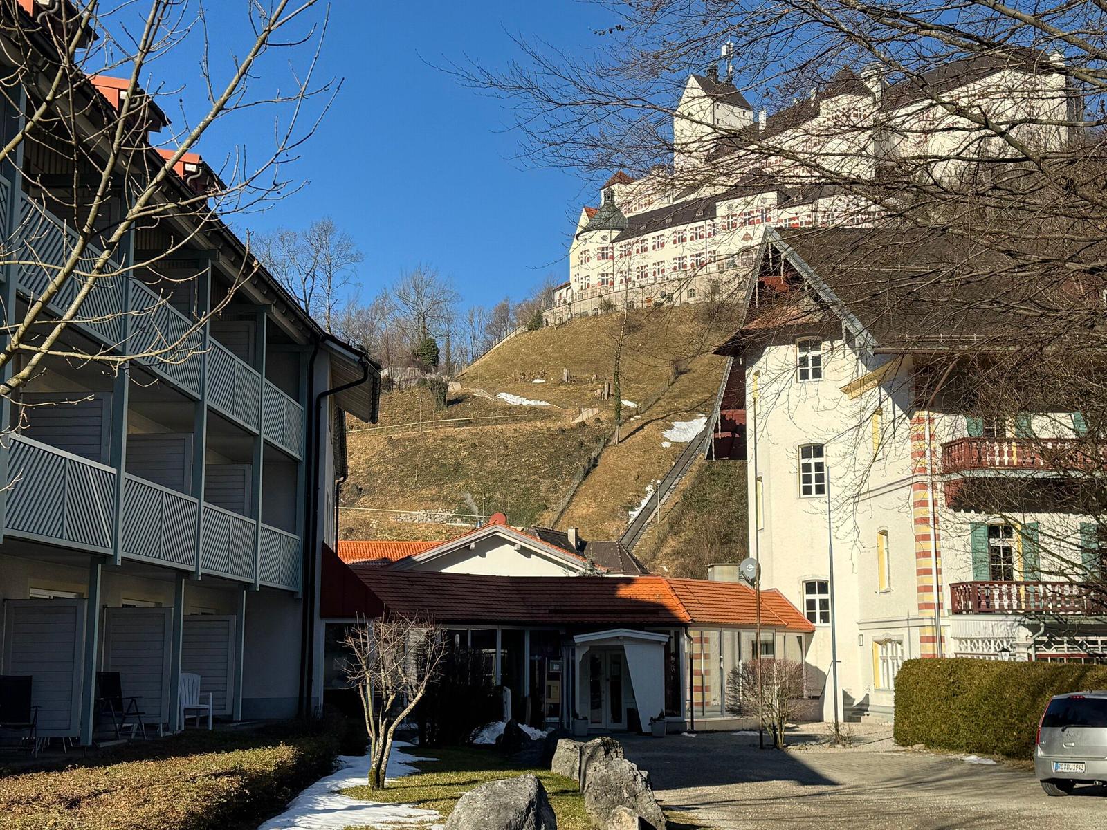 Ferienhaus mit Blick auf Schloss, begrünter Hof und Parkplatz.