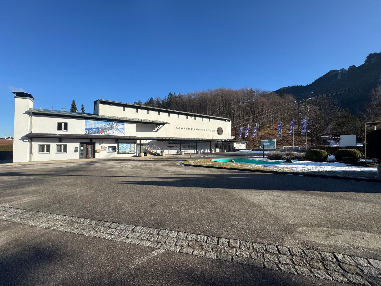 Ein Gebäude mit Skiliftanlagen und einem kleinen Pool im Vordergrund.