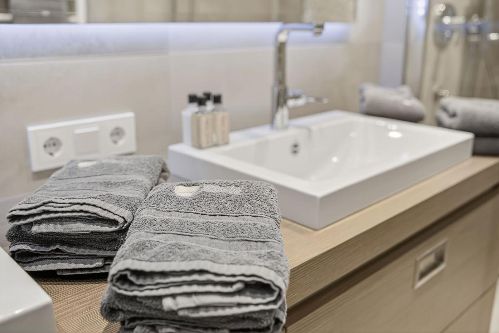 Bad mit Waschbecken, Handtüchern und Dusche