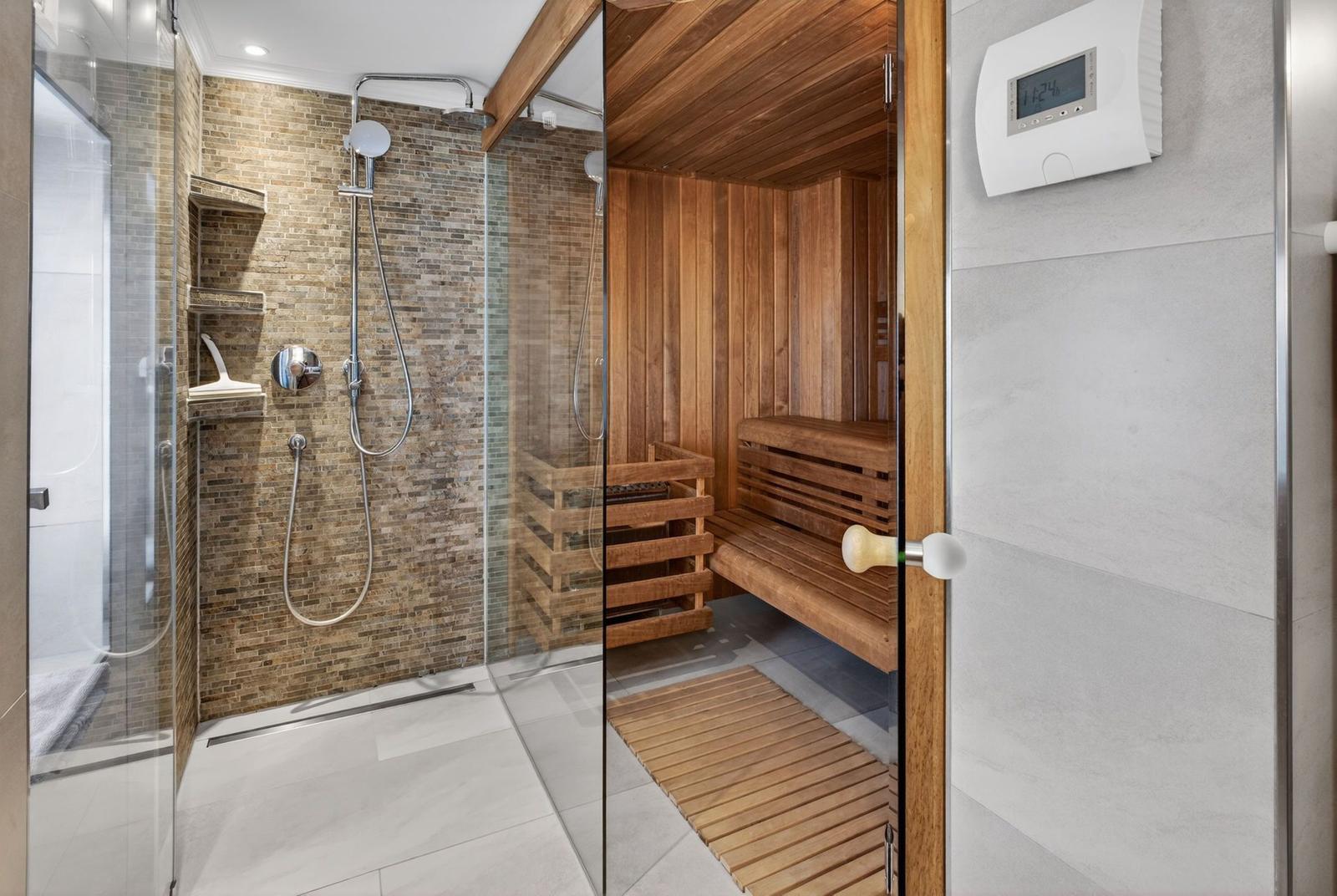 Dusche mit Steinwand und Sauna mit Holzbank und Thermostat
