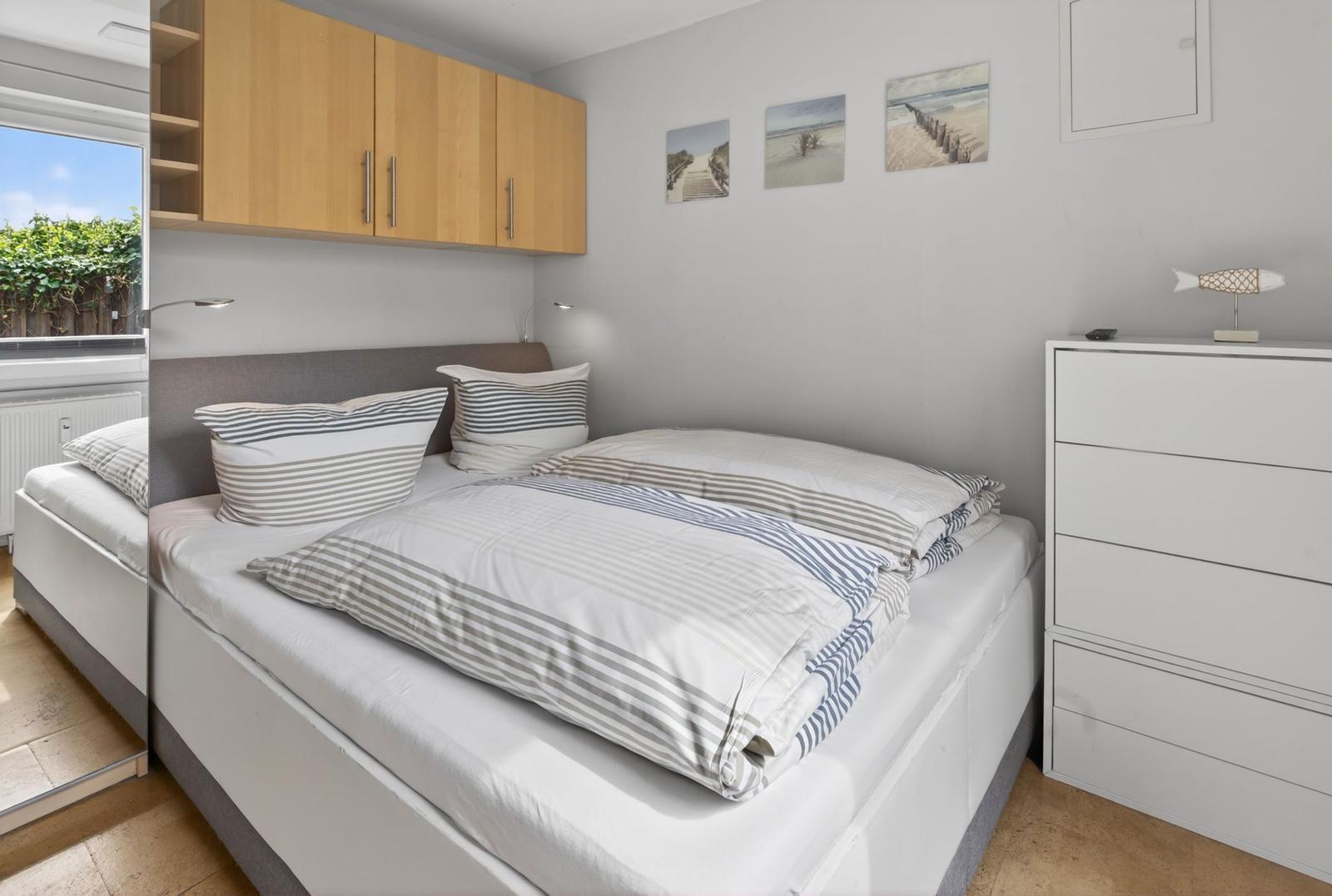 Schlafzimmer mit Doppelbett, Schrank und Wandbildern
