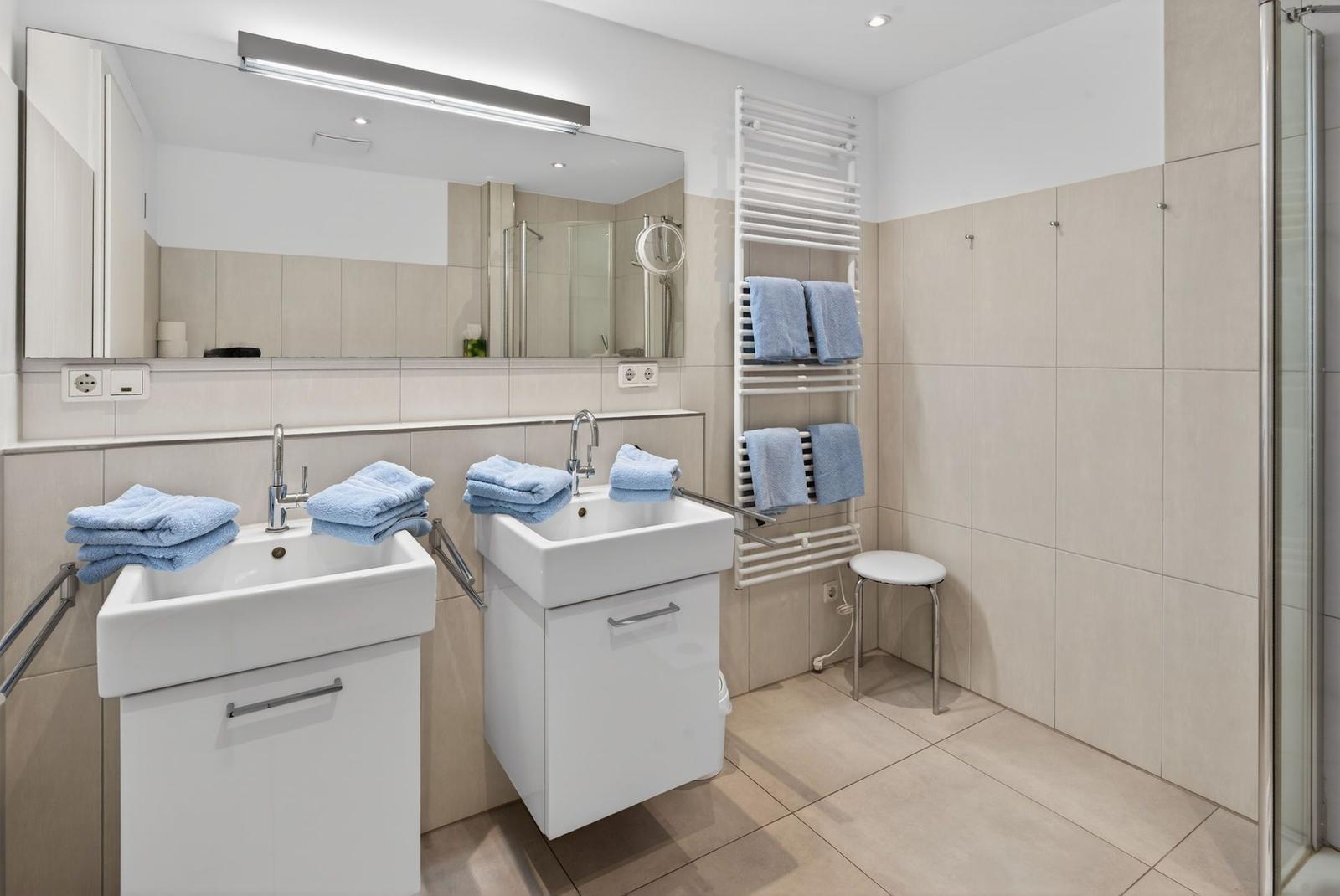 Badezimmer mit zwei Waschbecken, Spiegel und Dusche