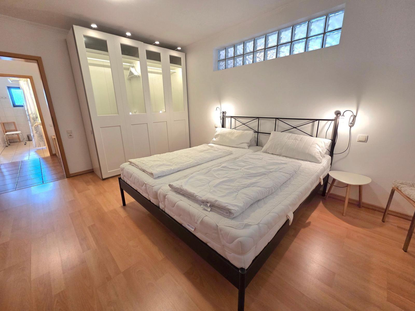 Bedroom with double bed, wardrobe, and floor window
