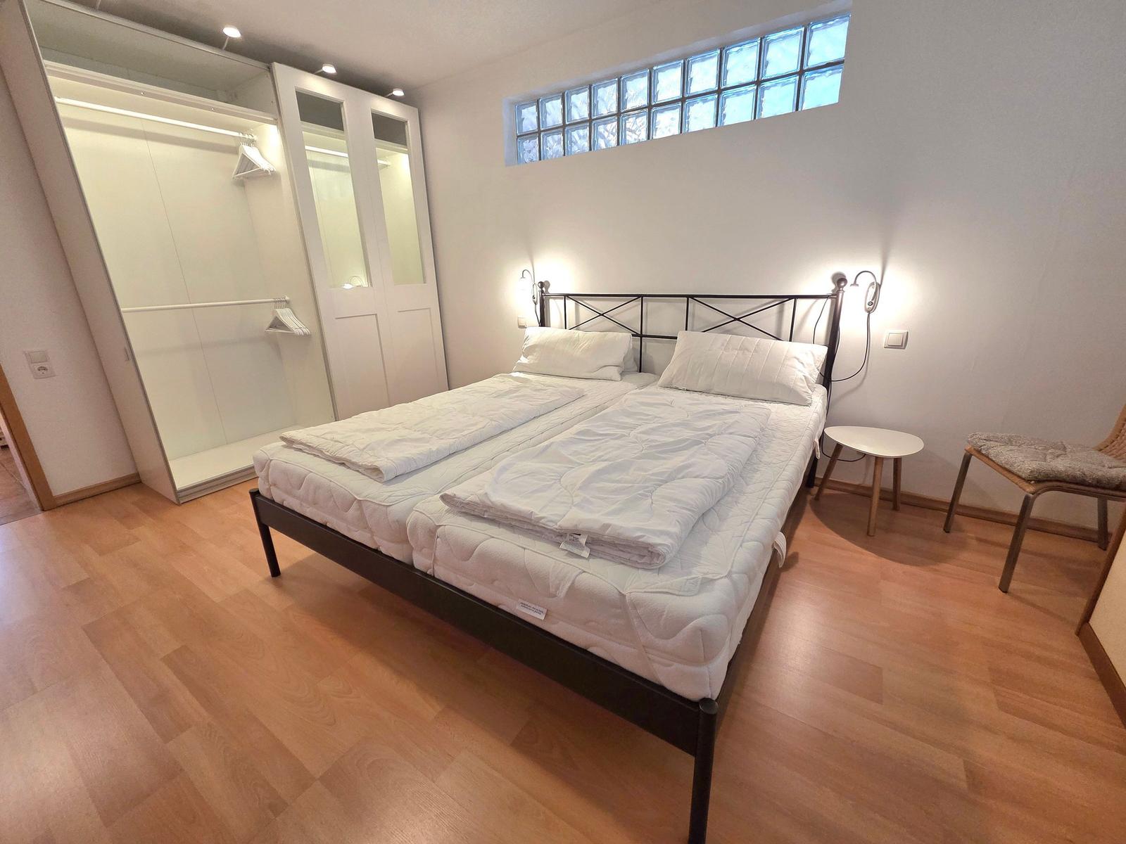 Bedroom with double bed, wardrobe, and glass window