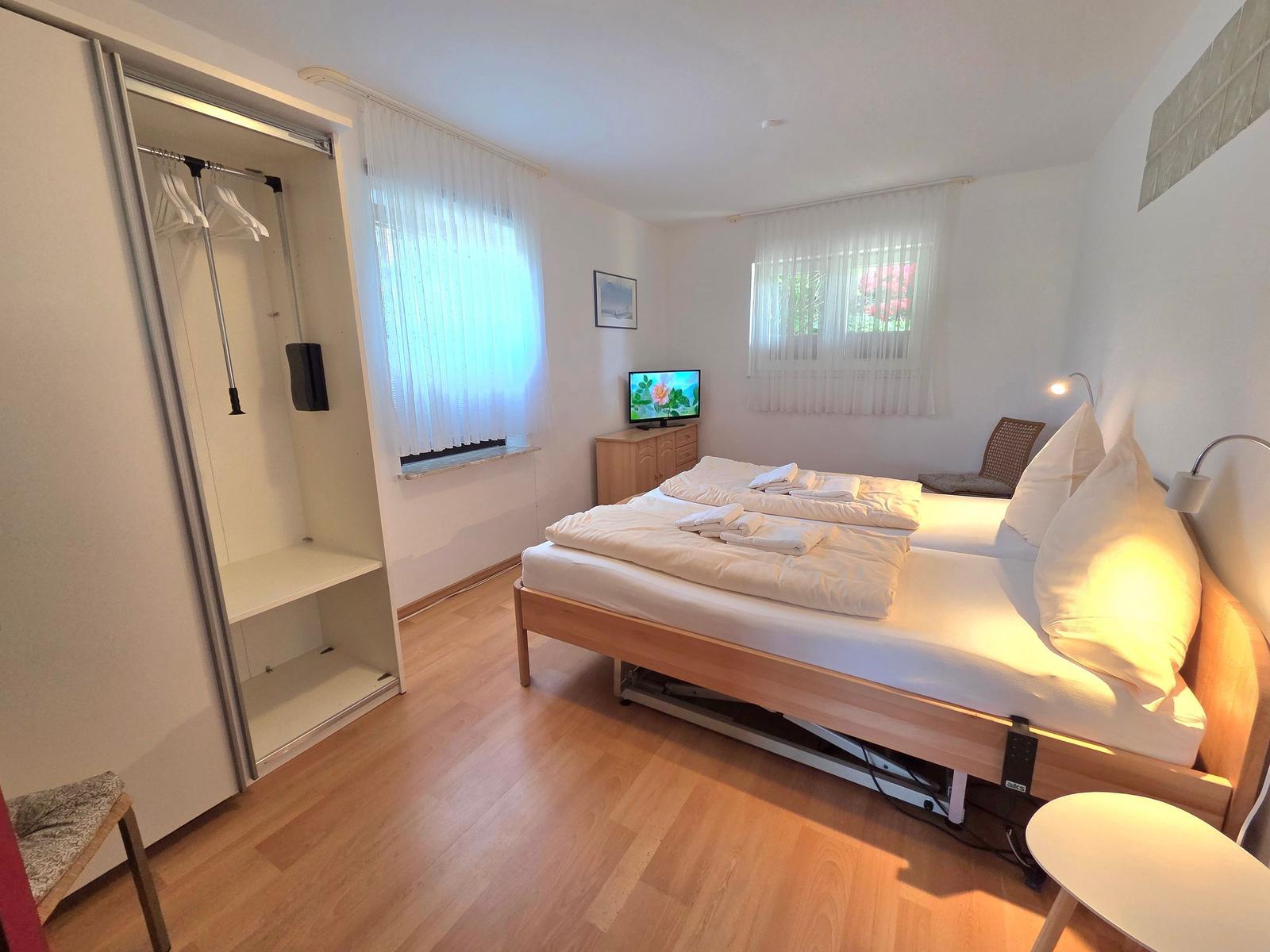 Bedroom with double bed, wardrobe, and TV.