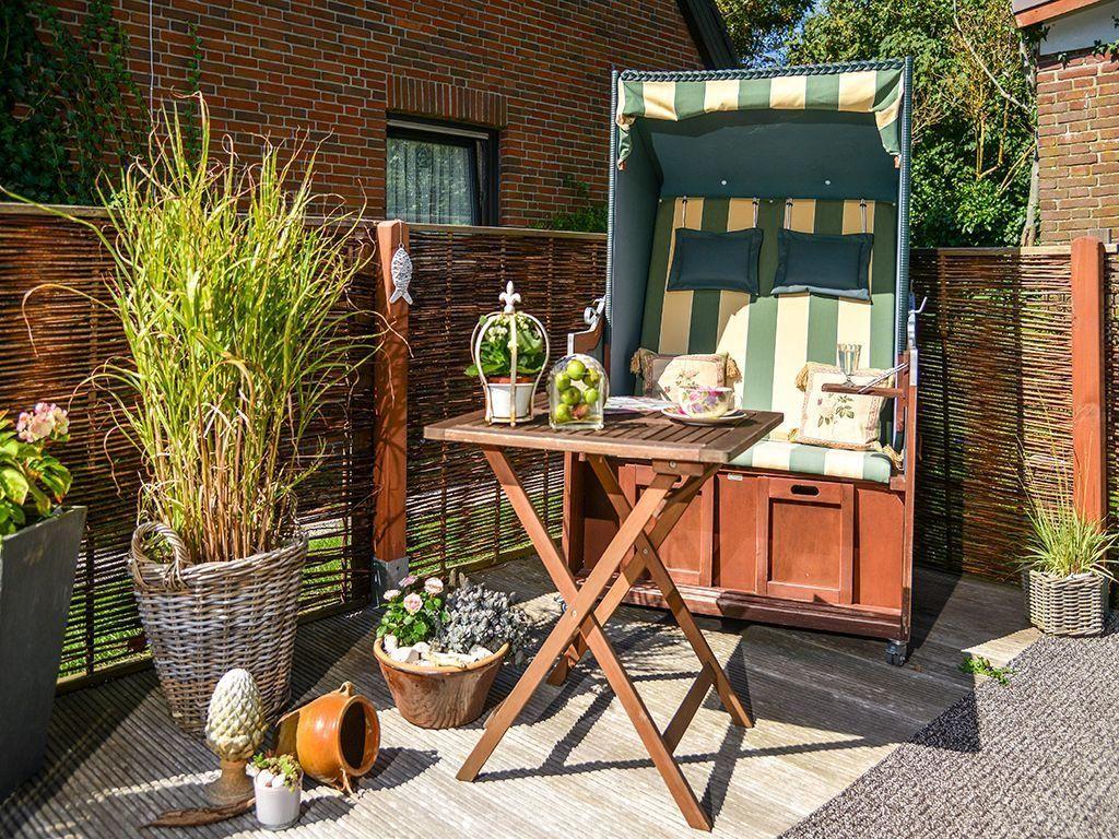 Garden with lounge chair, table, and plants.