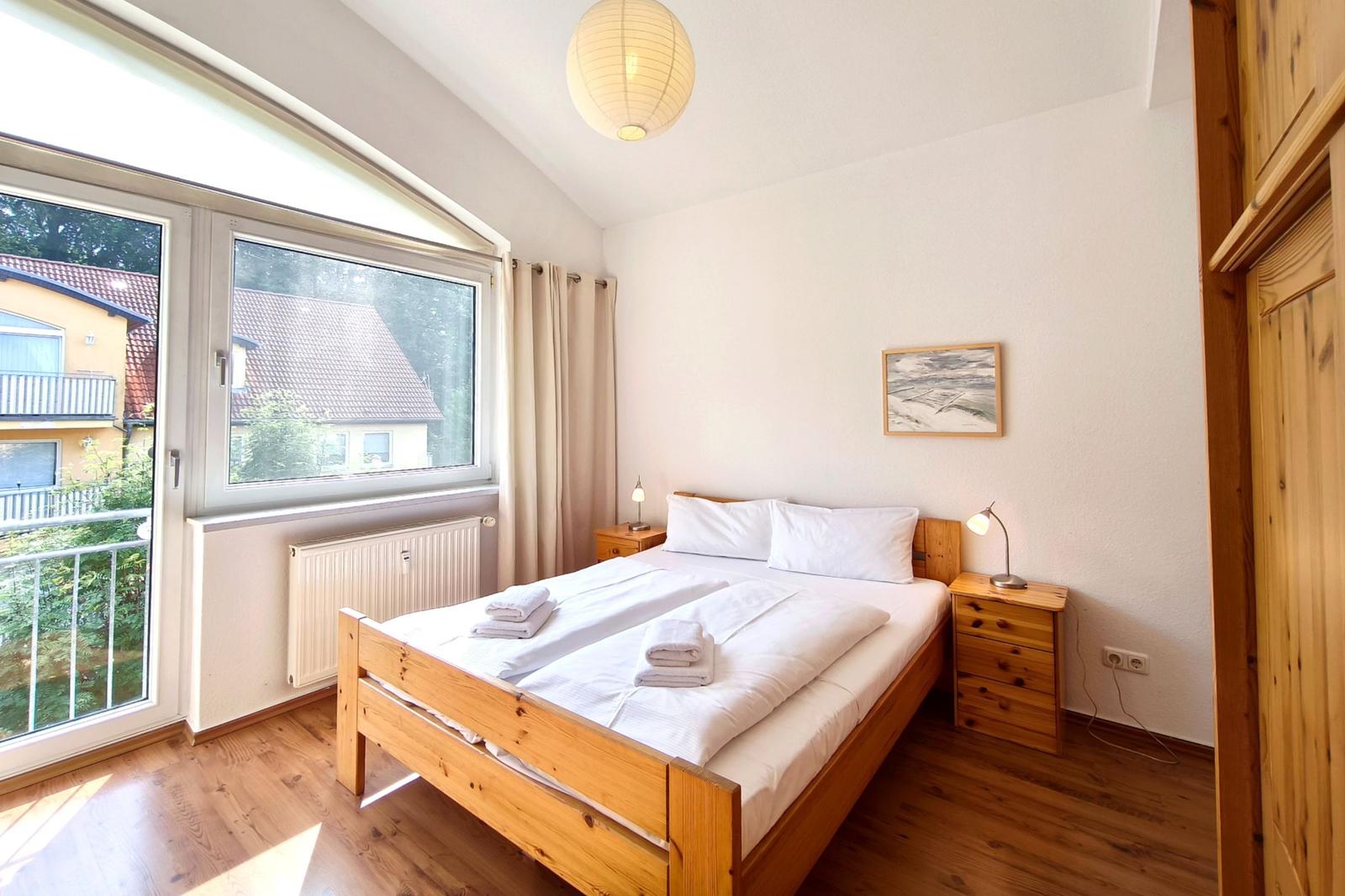 Behagliches Hauptschlafzimmer mit großem Doppelbett und Balkonzugang