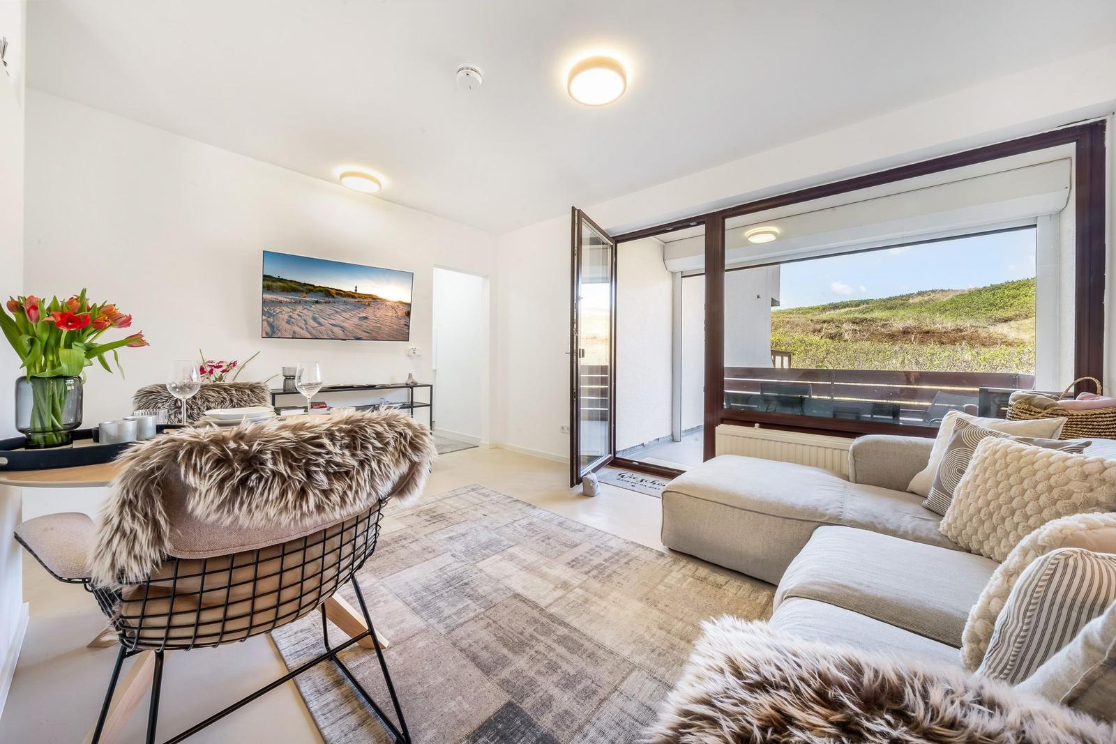 Living area with sofa, TV, and view of the dunes.