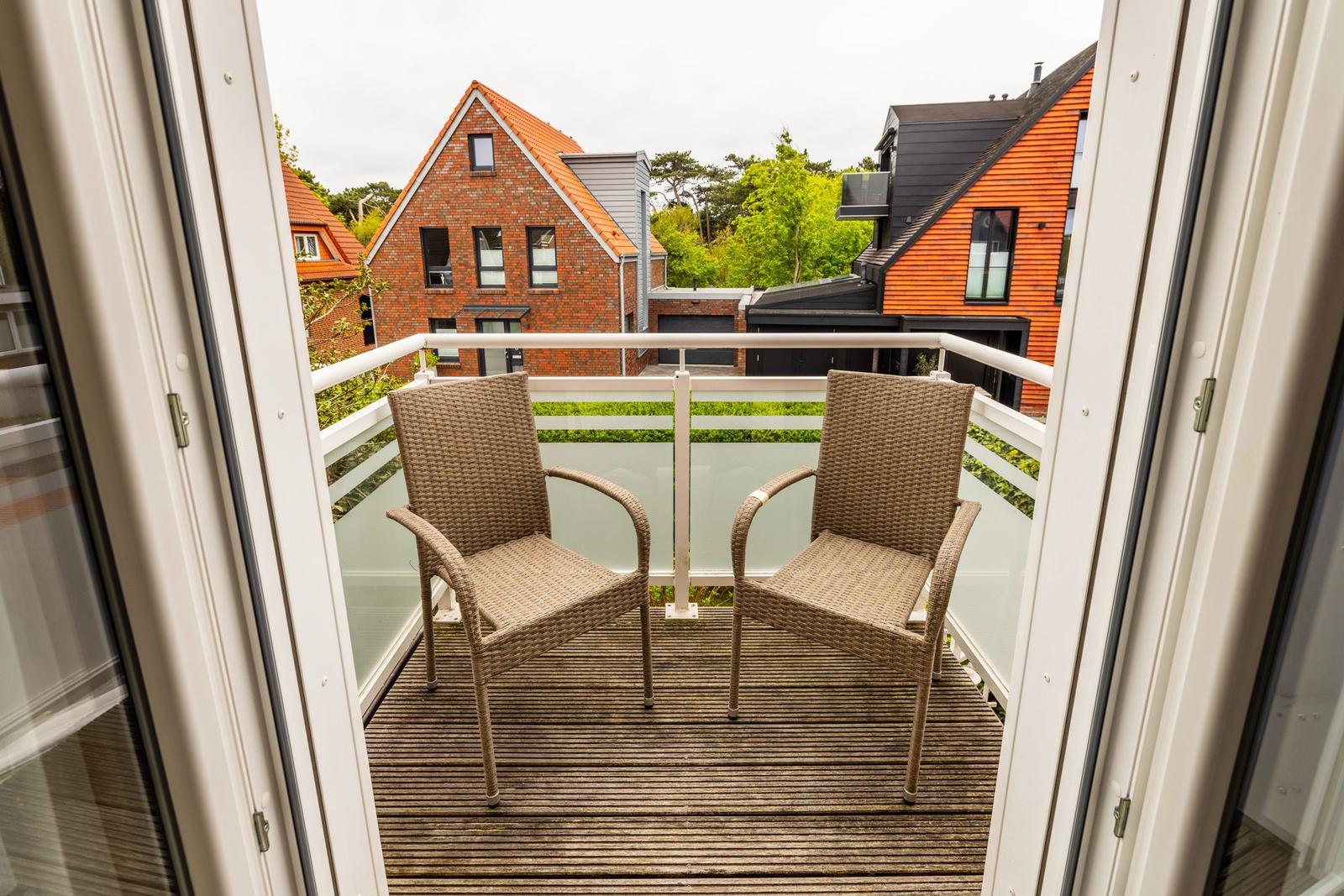 Terrasse mit zwei Stühlen und Blick auf Häuser und Grünflächen